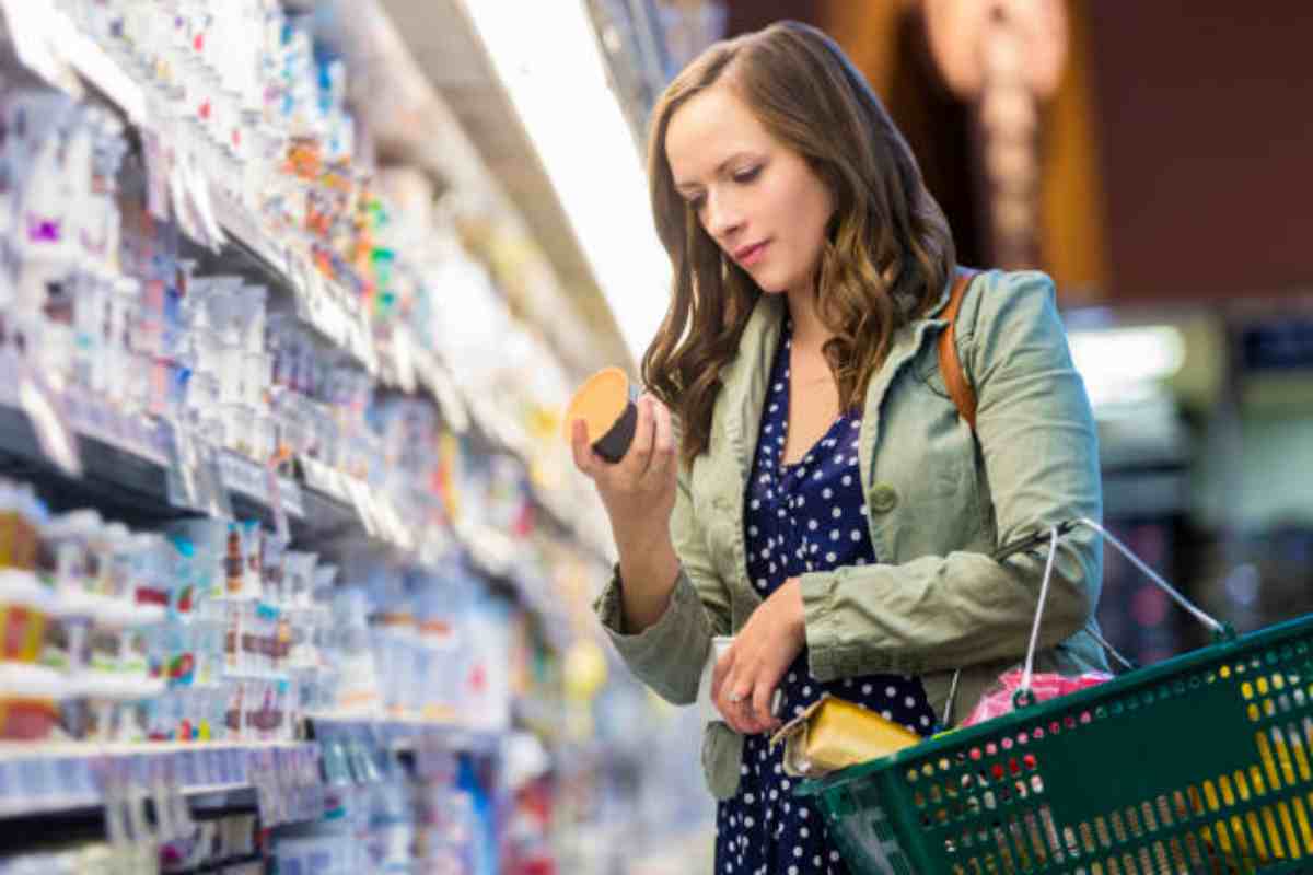 Ragazza legge le etichette degli yogurt prima di comprarli