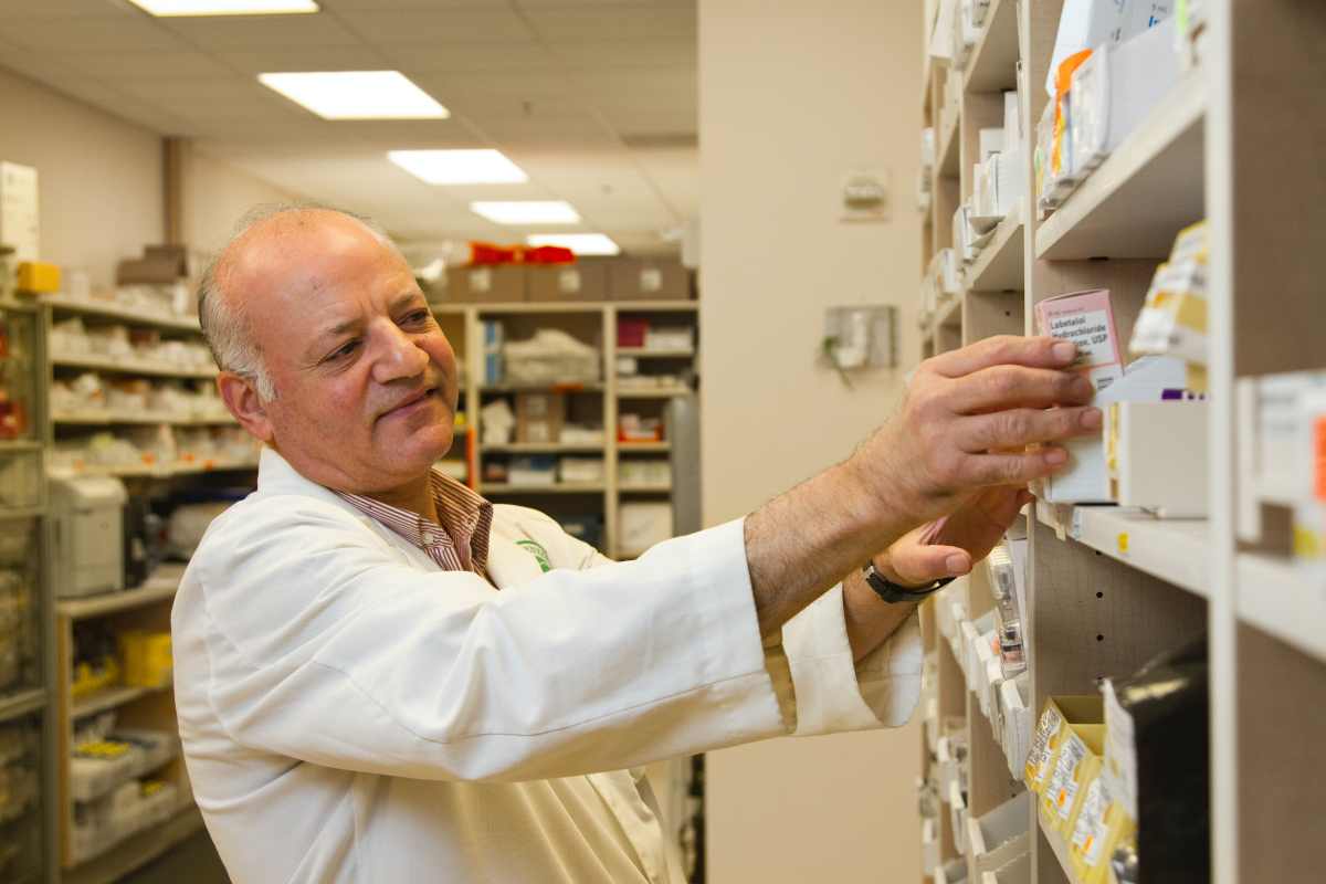 Dottore prende un farmaco da uno scaffale