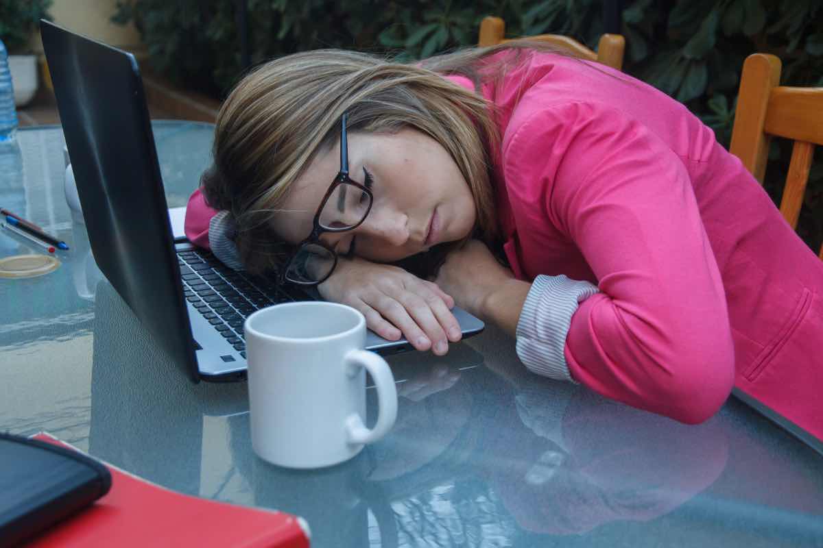 Una ragazza dorme appoggiata al pc