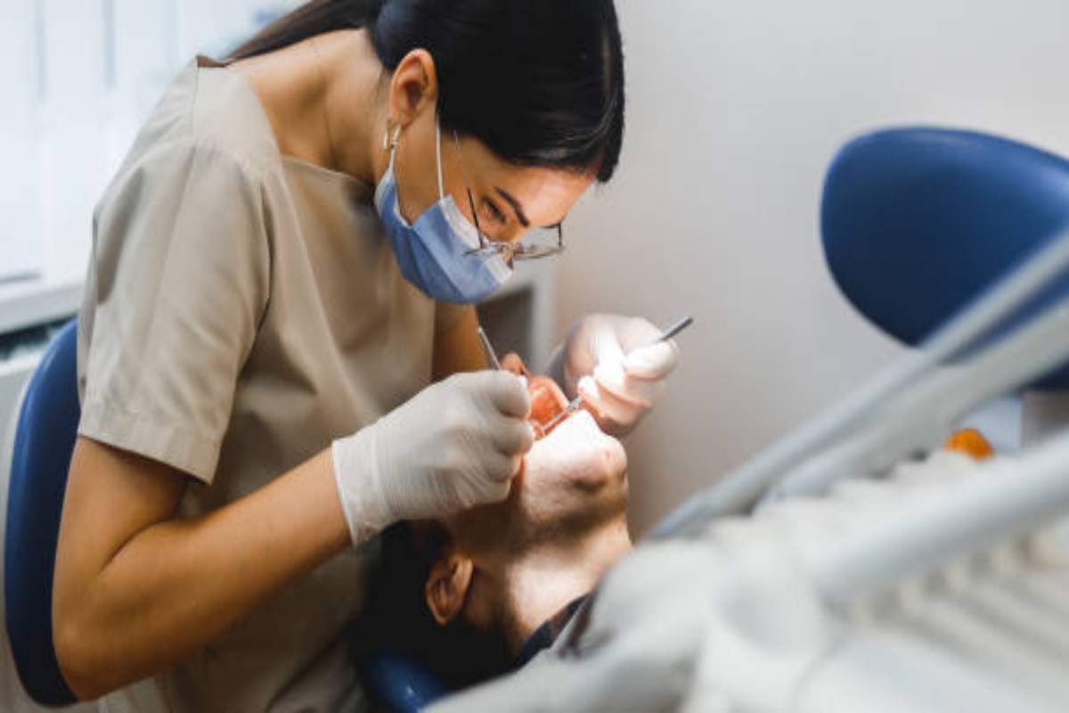 Dentista tratta una carie di un paziente