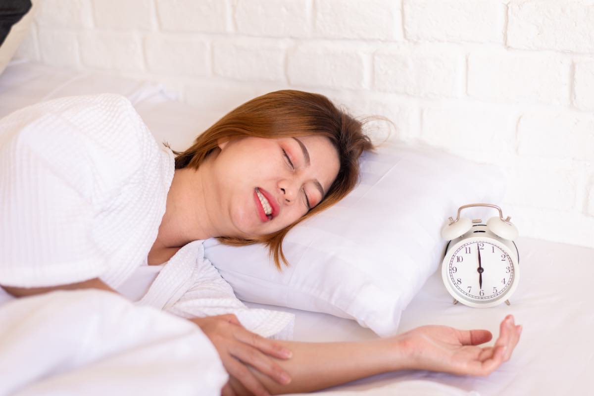 Una donna digrigna i denti mentre dorme