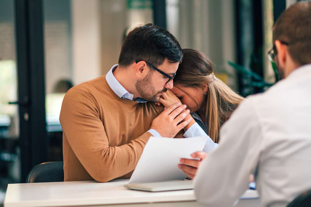 Un uomo conforta la sua compagna dopo aver ricevuto cattive notizia