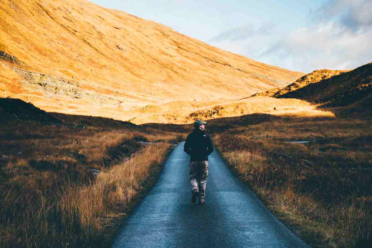 Uomo cammina su una strada in campagna