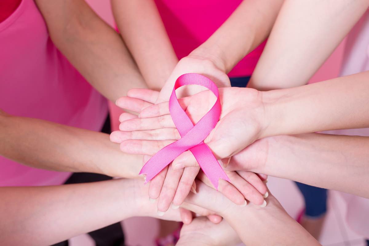 Un gruppo di donne tiene un fiocco rosa per la lotta contro il tumore al seno