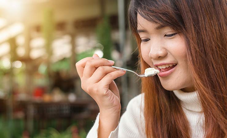 una ragazza mangia yogurt