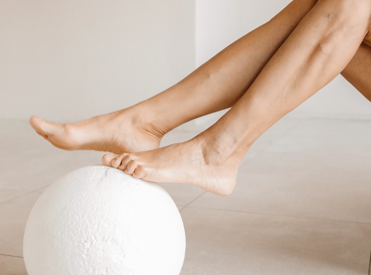 Una ragazza mostra le gambe appoggiate su di una palla