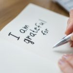 Una persona che scrive un diario della gratitudine